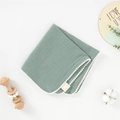Détail d'un gant de toilette en mousseline vert sauge avec bordure à pompons blancs - Vert Haricot