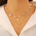 Close-up of layered gold necklace featuring pearls, starfish, and shell charms on model - Pink Beaded Starfish Shell Necklace(5749)