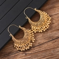 Détail de boucles d'oreilles géométriques dorées avec glands en style bohème vintage - Ton Or Avec Perles