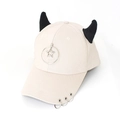 Detail of cream baseball cap with black devil horns, metal rings and a star charm - Star Beige