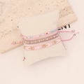 Detail of bohemian multilayer beaded bracelet set with pink woven cord and golden beads - Pink