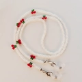 Detail of beaded glasses chain featuring red cherry accents and clear white beads - White with Red Cherry