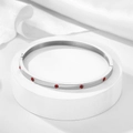 Detailed view of silver screw bangle with red zircon stones and 18k gold plating - 4mm / Silver-Red Zirconia
