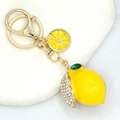 Macro view of lemon fruit keychain with yellow enamel plating and sparkling rhinestones - Gold and Yellow Lemon