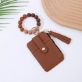 Close-up of brown lychee leather card holder with silicone beads and leather tassel - Brown