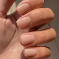 Glossy nude pink medium square press-on nails shown holding dark sunglasses - Medium Square / Beige