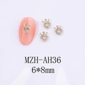 Vue macro des bijoux d'ongles couronne dorée 6x8mm avec strass blancs sur ongles roses - Style de Couronne (AH36)