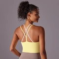 Dettaglio delle spalline incrociate sulla schiena di un reggiseno sportivo giallo - S / Giallo crema