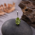 Macro shot of S925 silver pendant with pear-cut green gemstone on a dark pebble stone - Natural Peridot Water Drop Pendant Silver