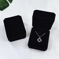 Elegant black velvet octagonal jewelry box with silver clover necklace on white background - Black