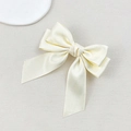Detail of a creamy satin double-layered bow hair clip with a smooth glossy texture - Beige