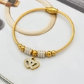 Détail d'un bracelet câble torsadé doré avec doubles breloques cœurs en zircon - Couleur Acier / Double Cœur