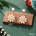 Detailed view of pearl flower earrings with dimensions 2.9cm by 1.64cm on wood stand - Pearl Flower Studs