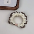 Close-up of cream scrunchie with brown checkered edges and a pink oval bead detail - Off-white with Coffee Plaid