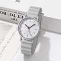 Minimalist light grey quartz watch with wavy silicone strap on artistic book background - Gray