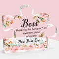Macro shot of puzzle-shaped acrylic plaque with pink floral patterns and boss thank you note - Boss Style (Q2)