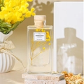Luxury reed diffuser with preserved yellow flowers in a glass bottle on stone base - Gardenia Story Set