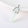 Hexagonal opal stone pendant with silver metal bail on a white ceramic plate - Opalite