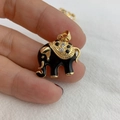 Handheld view of a gold and black enamel elephant pendant with sparkling crystals - Black