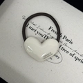 Detail of a white heart-shaped hair tie with FRANCE Handmade text on a beige fabric base - Milk White