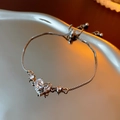 Macro shot of silver heart zircon bow bracelet with adjustable slider clasp detail - Silver