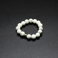 Macro shot of 4mm white stone elastic beaded ring with grey marble texture and silver bead - Howlite