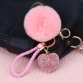 Pink heart keychain with plush ball and rhinestone charm on a leather bag - Rhinestone Heart + Pink Pom