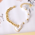 Elegant gold chain bracelet with irregular pearls and a large white heart charm - Heart