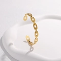 Detailopname van een minimalistische gouden schakelarmband op een wit plateau - Goud