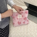 Pink plush travel makeup bag with red hearts and logo tag held by a hand - Light Pink Heart Cartoon