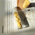 Essential oil roller bottle with Citrine crystals and light wood cap on book - Topaz