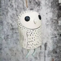 Close-up of handmade white owl garden wind chime with rustic hemp rope hanger - Owl