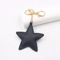 Detailed view of a black star PU leather keychain with gold hardware and pearl bead - Black