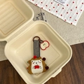 Detailed close-up of a handmade hedgehog charm with plaid lanyard in a minimalist gift box - Hedgehog with Apple