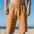 Khakifarbene Leinen-Shorts mit Kordelzug am sonnigen Sommerstrand im Detail - Erdgelb