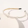 Detail view of champagne gold pearl headband with triple-row white pearls on display - Spaced Flower Pearls