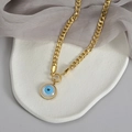Dettaglio della catena cubana dorata e ciondolo Evil Eye su base in pietra e seta - Collana