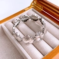 Close-up of vintage silver geometric stretch bracelet with clover patterns in wood box - Silver