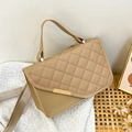 Khaki quilted crossbody bag with golden metal trim and fabric strap in a lifestyle setting - Khaki