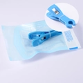Blue acrylic piercing clamp with metal spring in a sterile self-sealing pouch - Sterile Pouch-Blue Round Open Clamp