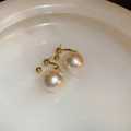 Dettaglio macro di orecchini vintage con perle e placcatura in oro su piatto bianco - Stile Orecchini a Bottone Oro Champagne / Perla Oro Champagne