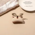 Detailed view of matte cream bow hair claw clip on elegant silk fabric background - Beige Matte-Butterfly