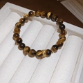 Macro view of tiger eye beads with golden hollow charm on a luxury jewelry box - Gold Coffee (With Exquisite Gift Box)