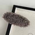 Close-up of brown plush faux fur oval hair clip with soft texture on a clean background - Tan