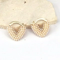 Detalle de pendientes de corazón en oro con perlas sobre una superficie de piedra - Estilo 7/Pendientes de Gota de Perla de Corazón