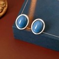 Nahaufnahme von Vintage-Silberohrringen mit blauen Steinen auf einer dunkelblauen Box - Silbernadel-Blau