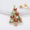 Macro shot of green enamel Christmas tree brooch with rhinestones and red bow detail - Classic Christmas Tree