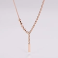 Detalle de collar en Y de oro rosa con cadena asimétrica y colgante de barra rectangular - Oro rosa