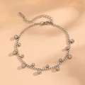 Close-up of silver stainless steel anklet with round cubic zirconia on orange background - Steel-colored Rhinestone Bracelet O602