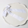 Elegant white satin double bow hair clip with long ribbons on decorative white tray - White
